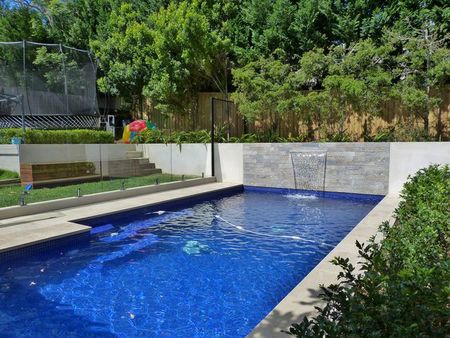 Fully tiled royal blue pool with feature wall and fountain