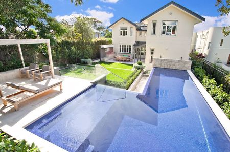 Fully tiled royal blue pool with infinity edge large ledge and feature wall and pergola image 2