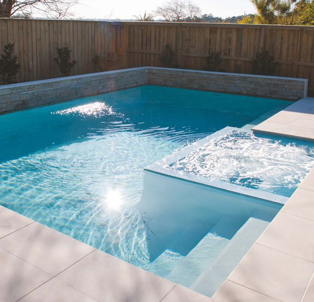 Light blue pool and spa with feature wall and fountain