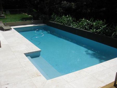 Pale blue pool with ledge and integral feature wall