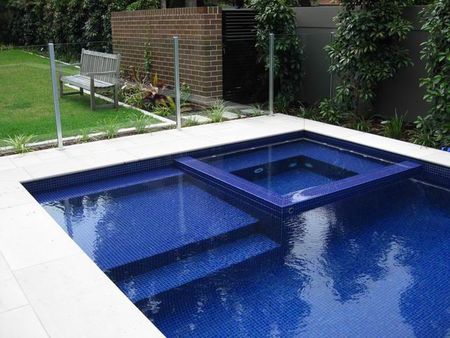 Fully tiled royal blue pool and spa with large ledge