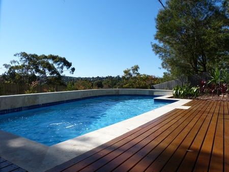 Light blue pool with deck and curved feature wall