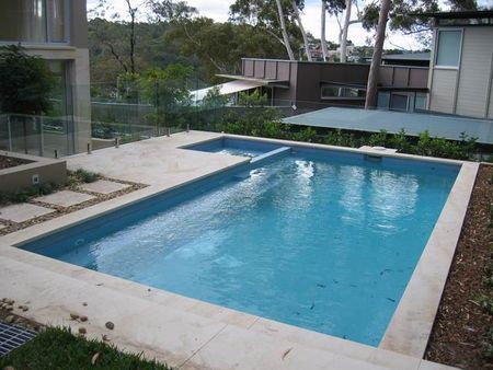 Light blue pool and spa with stepping stones