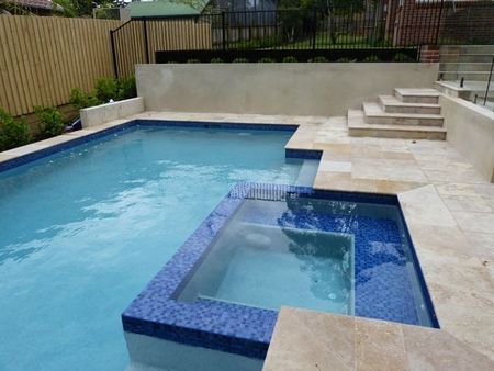 light blue pool and spa with tiled spa seat