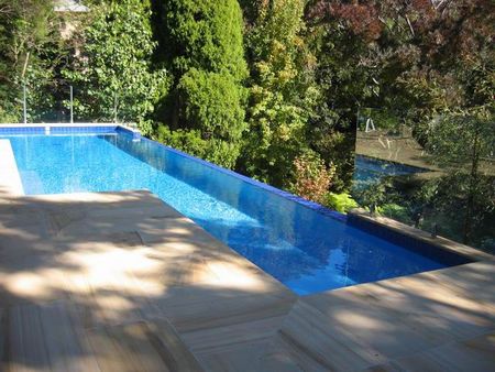 Infinity edge pool with lap lane and sandstone pavers