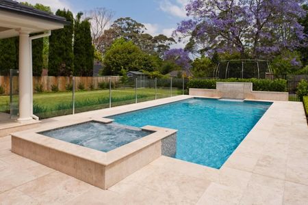 Raised spa light blue pool with feature wall and fountain