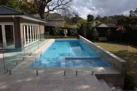 Light blue pool and spa with feature wall and cabana