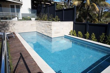 Mid blue tiled pool with sandstone wall