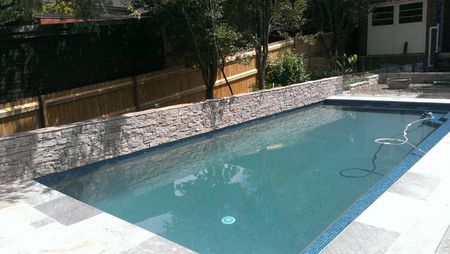 Green pool with stone cladding feature wall