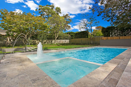 White tiled pool with spa and fountains