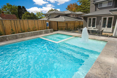 White tiled pool and spa with large ledge and geyser